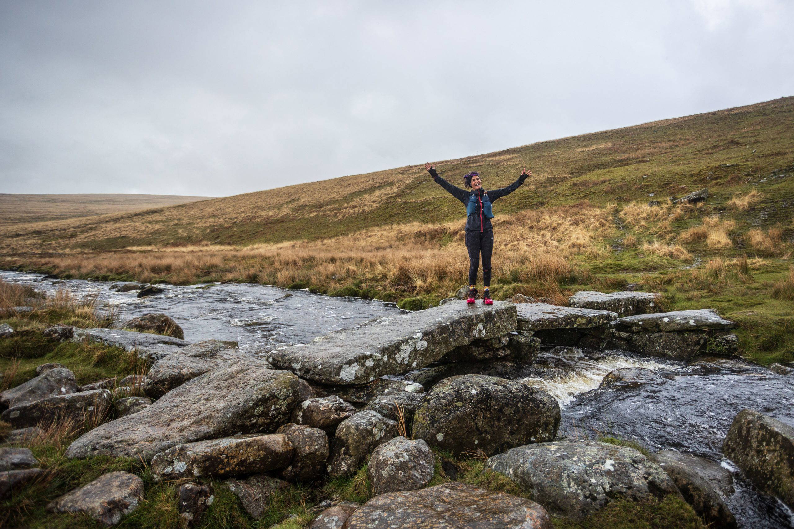 An image of a woman in the middle of the moors posing for a photo