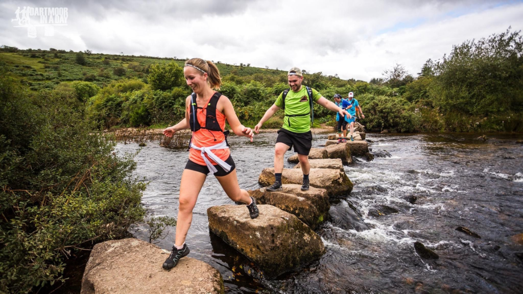 An image of multiple event-goers crossing over a river.