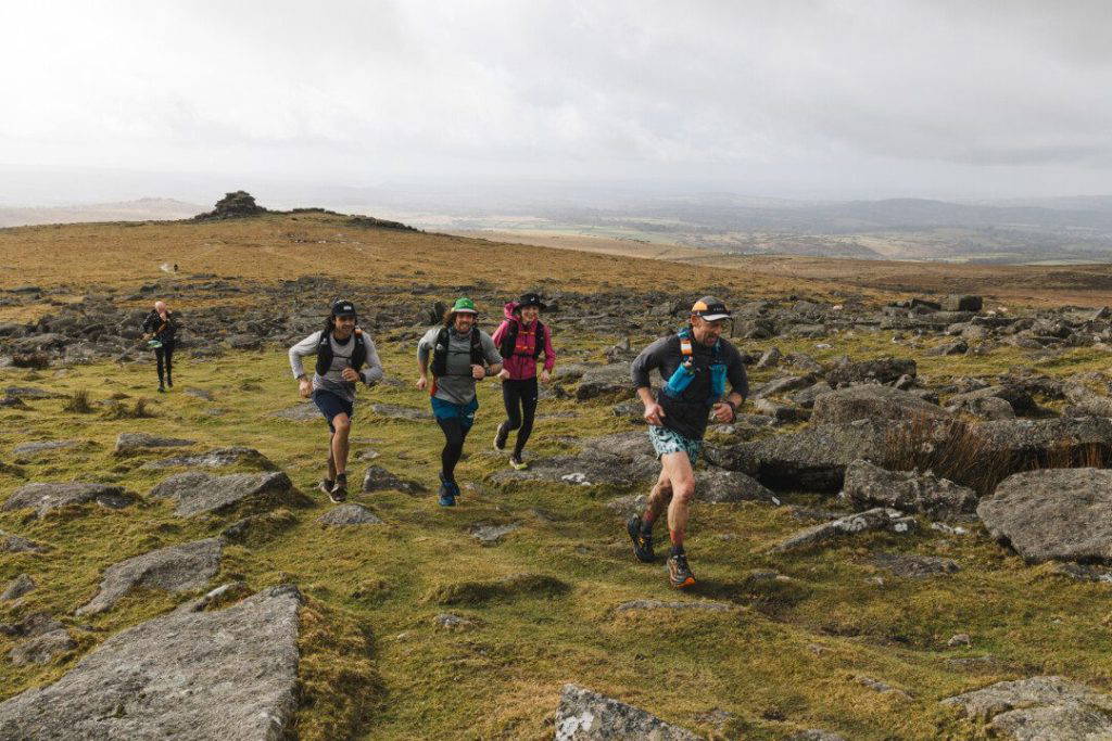 An image of a group of people jogging across natural terrain.