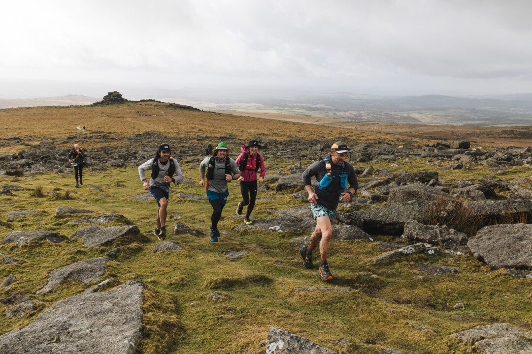 An image of a group of people jogging across natural terrain.