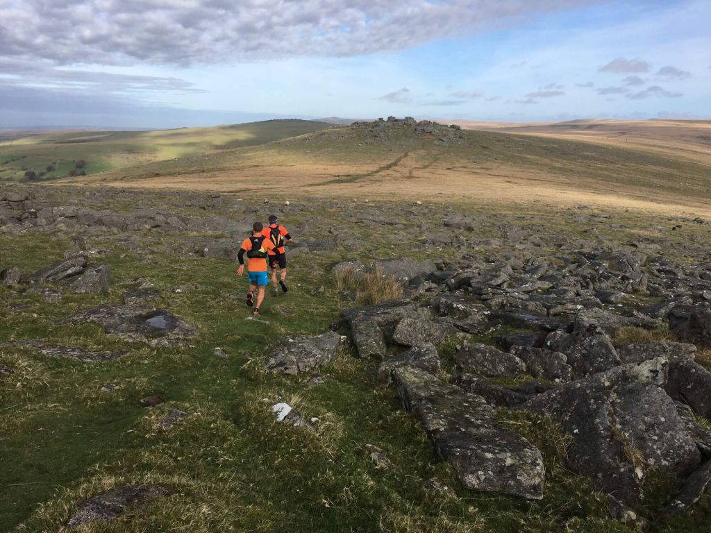 An image of a group of people jogging across natural terrain.