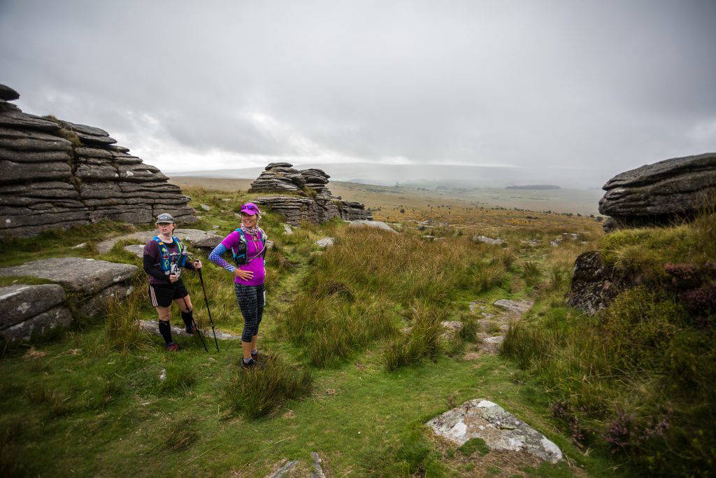 An image of two women hiking in a field.