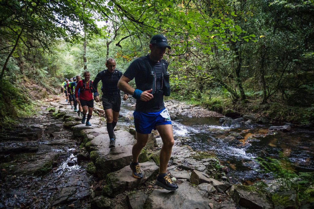 An image of a group of people jogging across natural terrain.