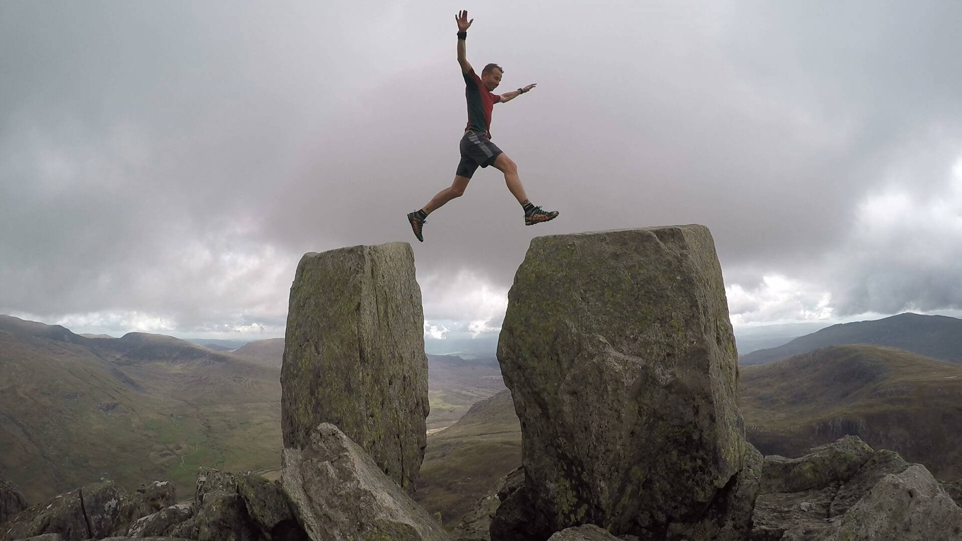 An image of an individual leaping from one rock to another.