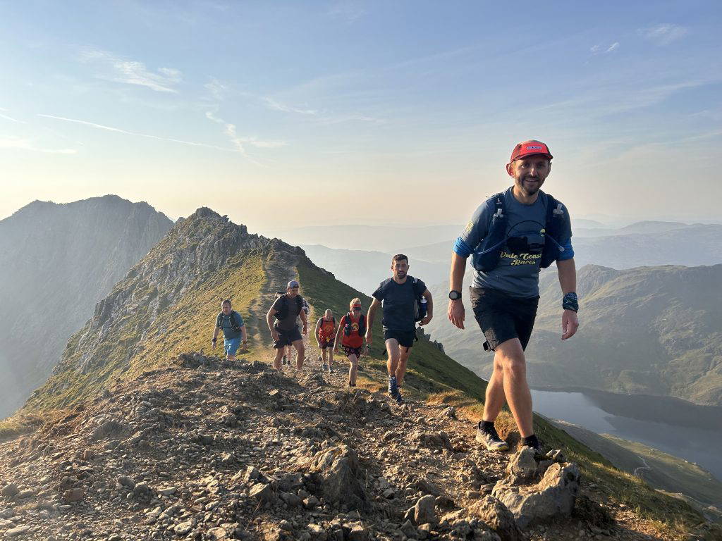 An image of a group of people jogging across natural terrain.